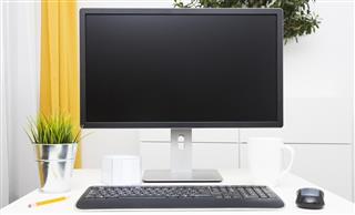 Blank monitor on table in bright interior