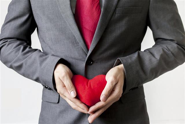 Businessman showing compassion holding red heart in his suit