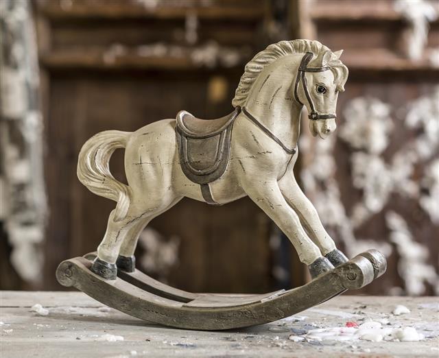 Vintage old rocking horse on a wooden background