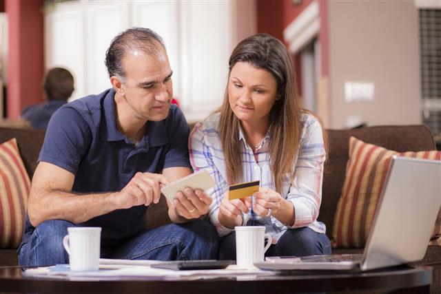 Latin descent couple paying monthly bills at home