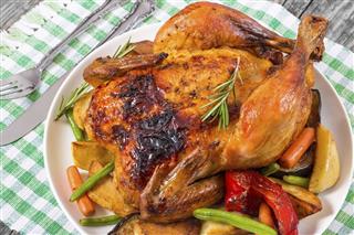 Roasted whole chicken potatoes baby carrots eggplants green