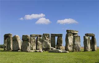 Stonehenge with green grass and blue sky