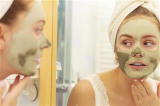 Woman face with green clay mud mask