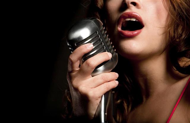 Beautiful singer singing with microphone