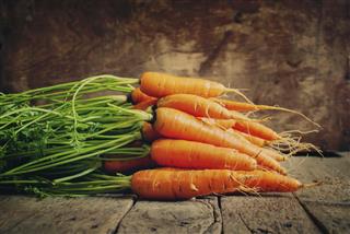Fresh Organic Carrots lies on wooden background horizontal ton