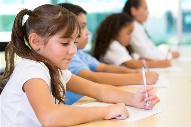 Diverse students writing assignment in private school classroom