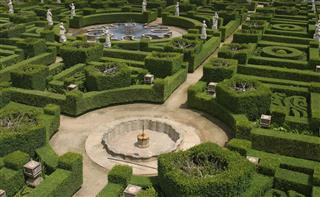 Intricate hedge maze with fountains and statues