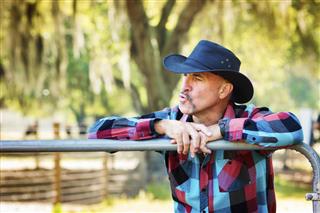 Mature cowboy whistling or calling his cattle