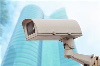 Dirty CCTV security camera with blurred office building background