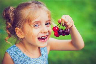 Little girl with a cherry