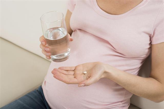 Pregnant Woman Hand With Glass Of Water And Vitamin Pill