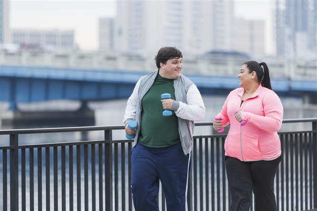 Overweight Hispanic man and woman exercising together
