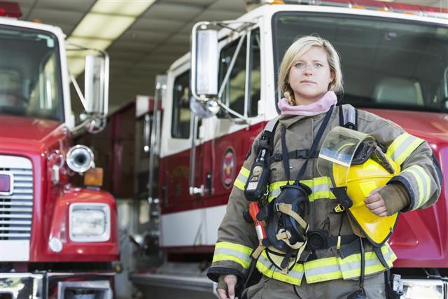 Female firefighter standing in front of fire truck