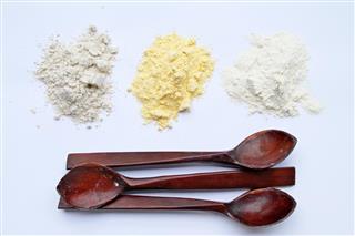 Three types of flour with three wooden spoons