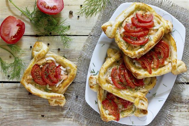 Cakes with red fish (salmon and puff pastry) and tomatoes