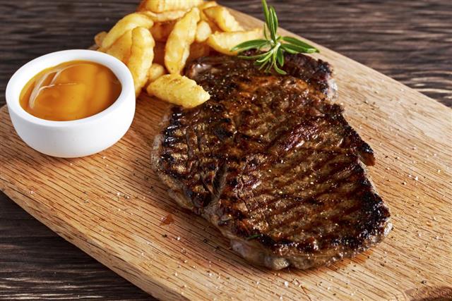 Grilled Beef Steak with Chips and Mango souce on wooden
