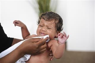 African American Woman Wiping Vomit From Newborn