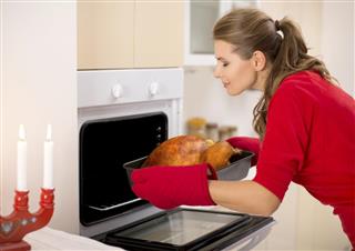 Woman preparing roasted turkey for dinner