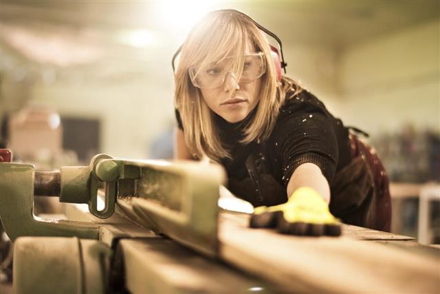 Female craftsperson working with plank
