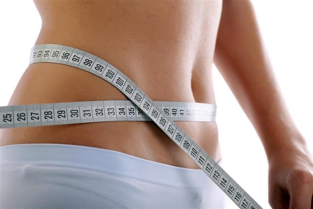 Close up of a slim waist with measuring tape