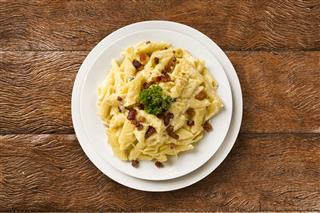 Pasta carbonara served on penne with bacon and cheese