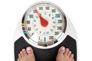 A woman weighing herself on bathroom scales
