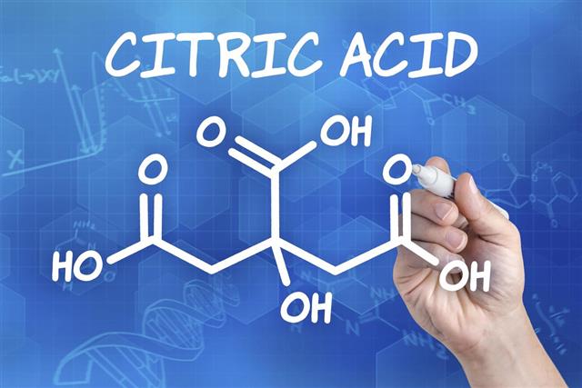 Hand with pen drawing the chemical formula of citric acid