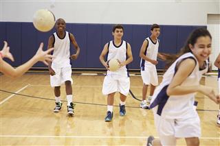 High School Students Playing Dodgeball In Gym