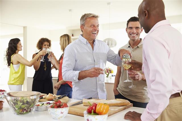 Group Of Mature Friends Enjoying Dinner Party At Home