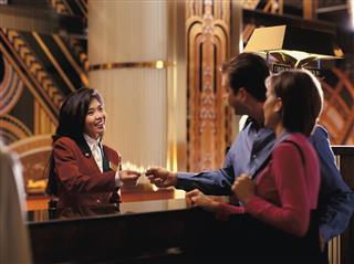 Female receptionist giving room key to couple