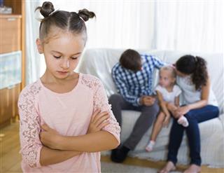Girl sad because of jealous younger sister to parents