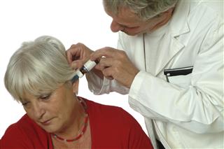 Senior woman patient and Doctor applying eardrops