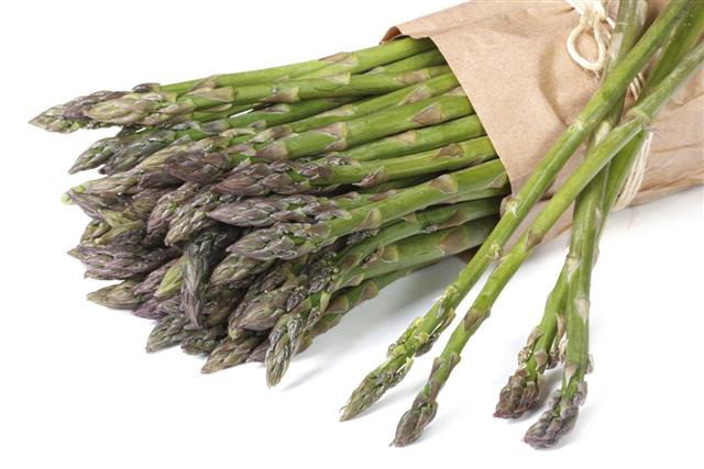 Asparagus in paper bag isolated on white