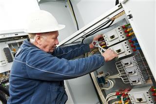 Electrician tighten the screws with spanner