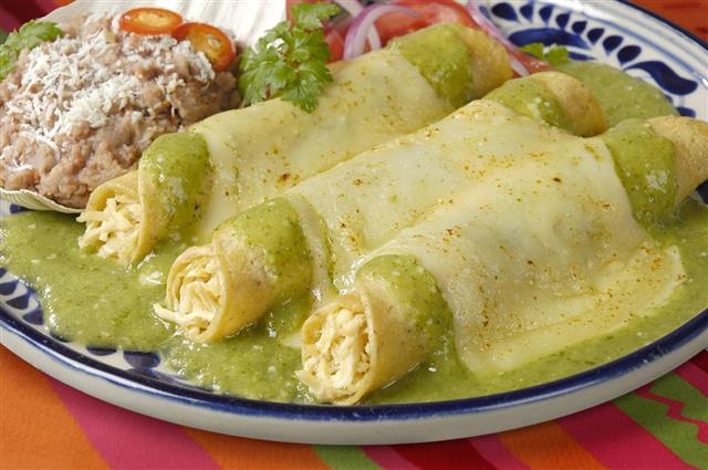 Enchiladas filled with cheese and covered in green sauce