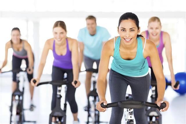 Spinning Class Exercising Together In Gym