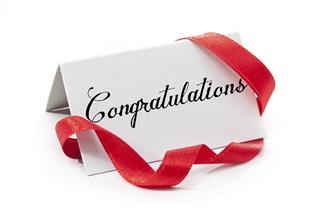 A white congratulations sign and red ribbon
