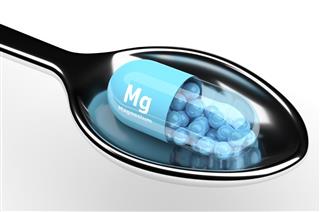 3d magnesium pill on spoon over white