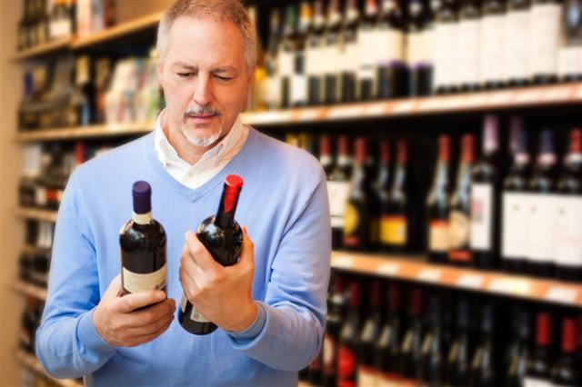 Man choosing between two bottles of wine