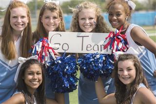 Sports: Group of high school cheerleaders with 'Go Team' sign.