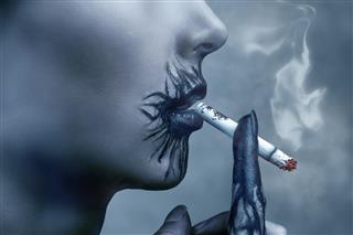 Sick woman smokes a cigarette side view