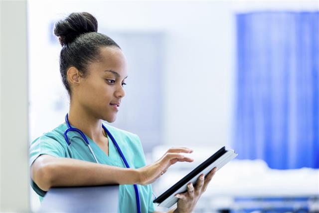 African American nurse or doctor using digital tablet in hospital