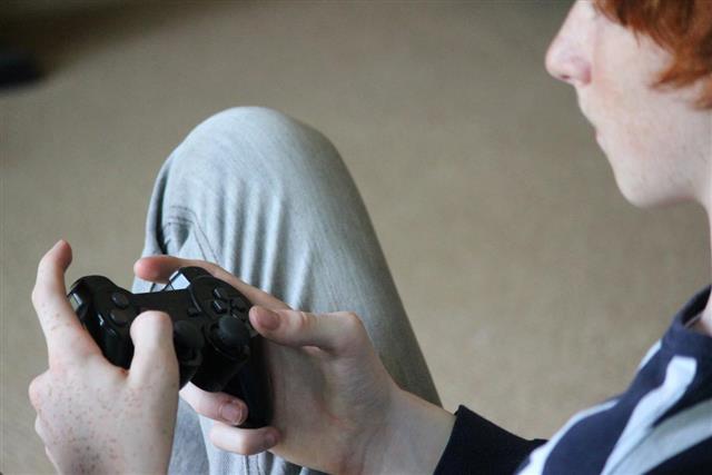 Image of boy playing computer game gaming controller video game
