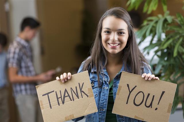 Teenage girl hold 'thank you' sign at clothing drive