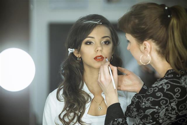 Professional makeup artist makes up lips beautiful attractive model celebrity