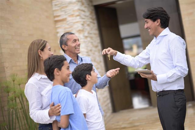 Real estate agent giving keys to a family