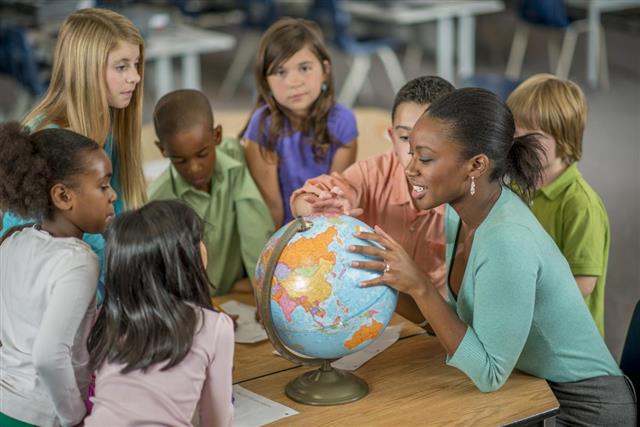 Teacher Showing Students Places on a World Globe