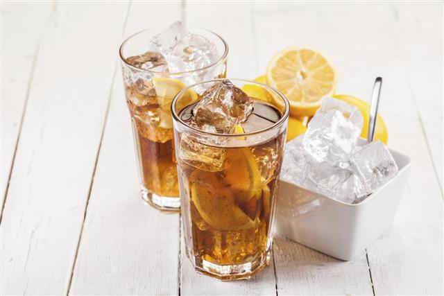 Two glasses of lemon ice tea on a white wooden table