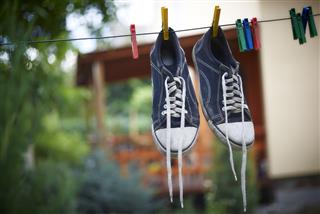 Black sneakers are hanging on a clothesline