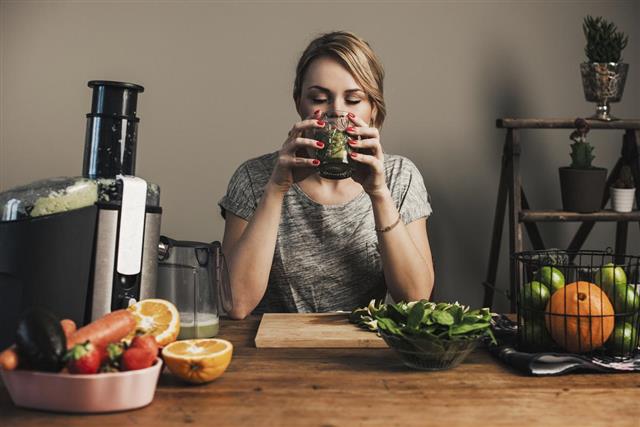 Woman juicing with fresh fruit